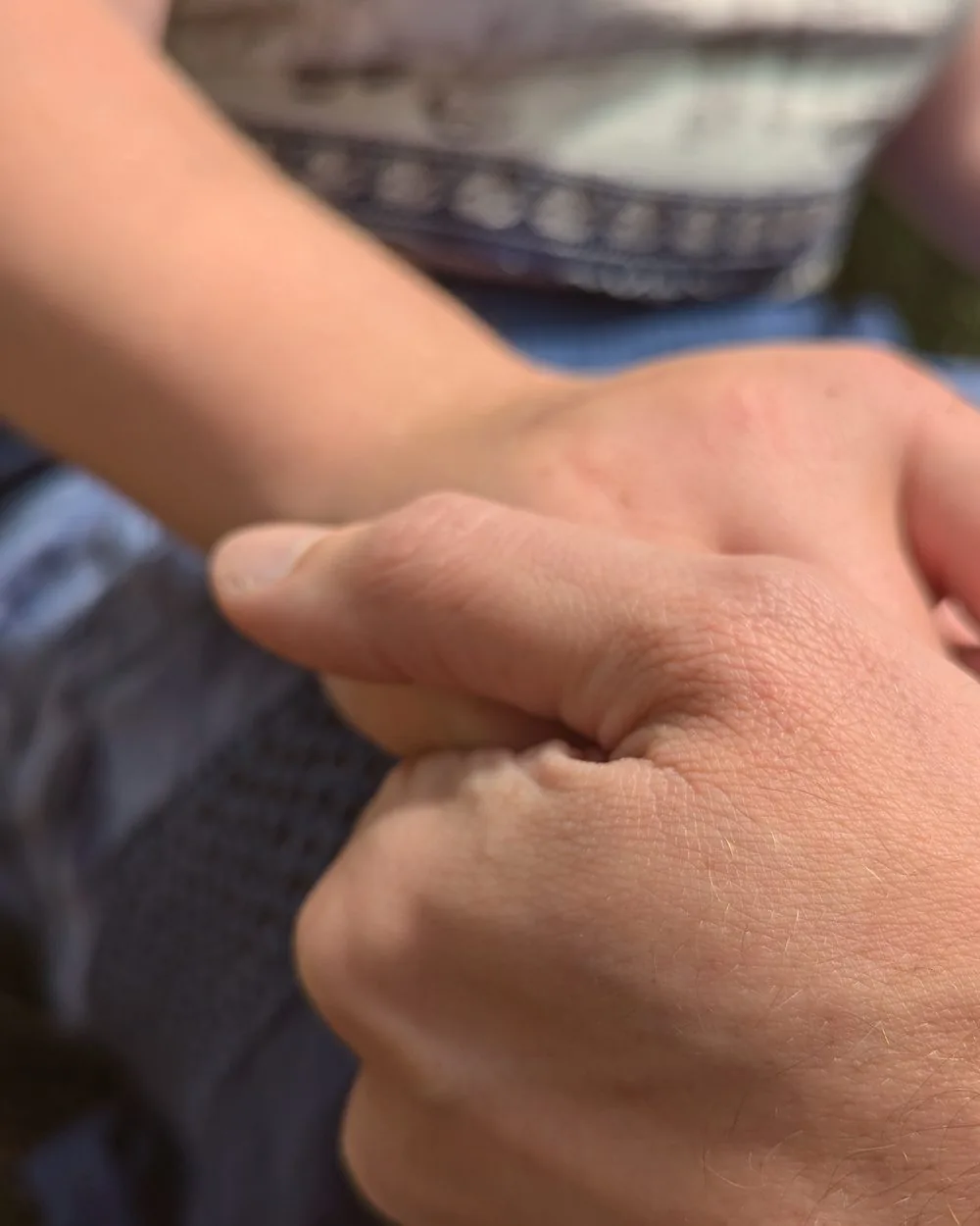 Een hand rust op een arm.