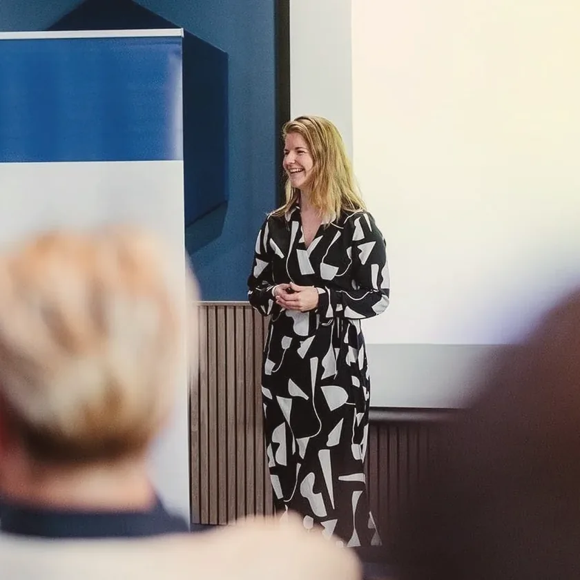 Els spreekt een groep toe tijdens een in-company sessie.