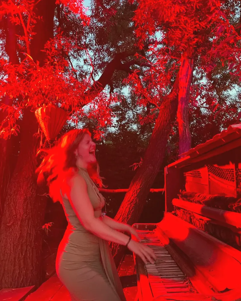 Els achter de piano in rood licht.